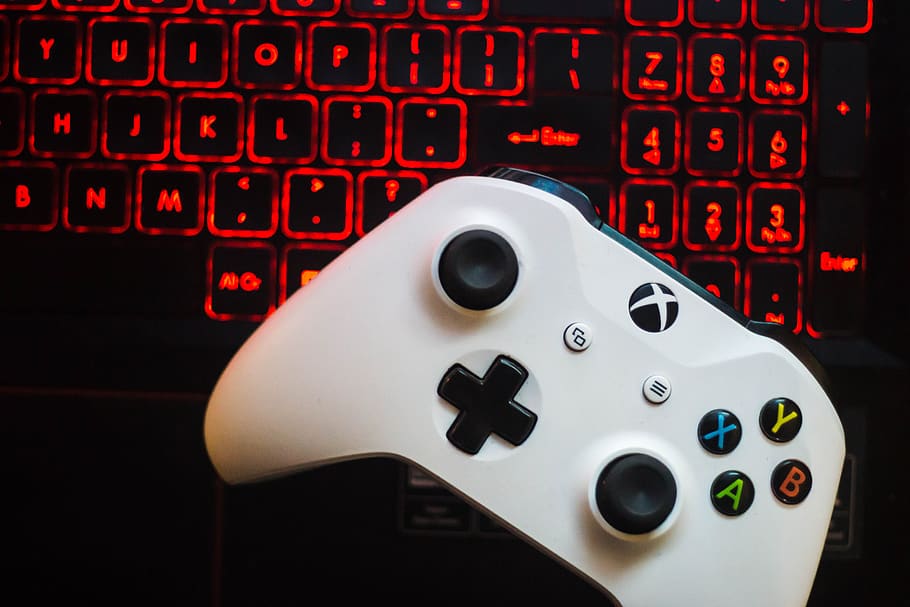 An Xbox One controller resting next to a keyboard for Hell Let Loose Server Hosting.